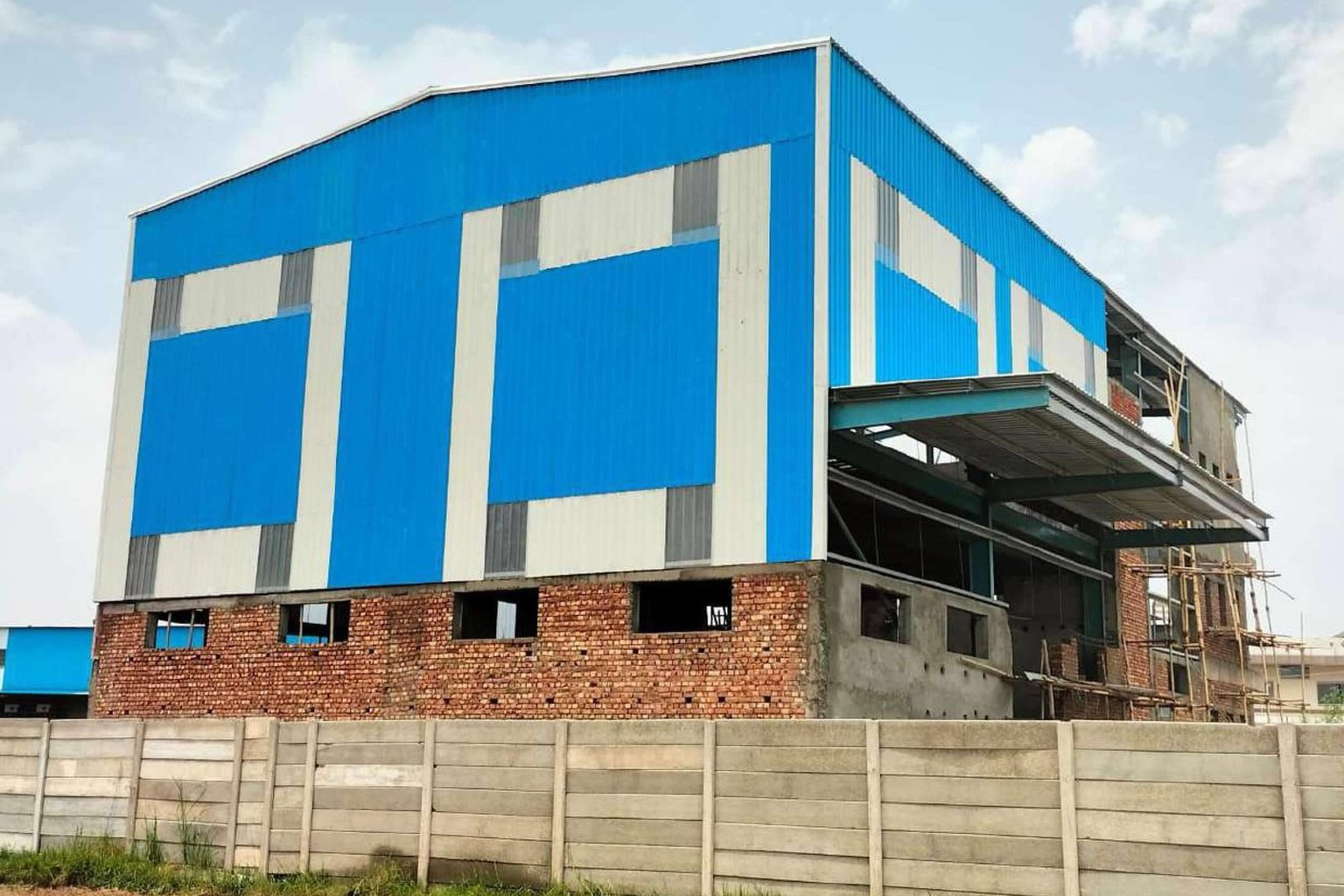 Factory building clad in colour-coated sheets by Mahawar Prefab Solutions